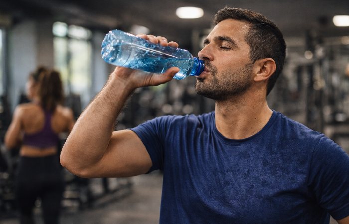 person drinking water during workout